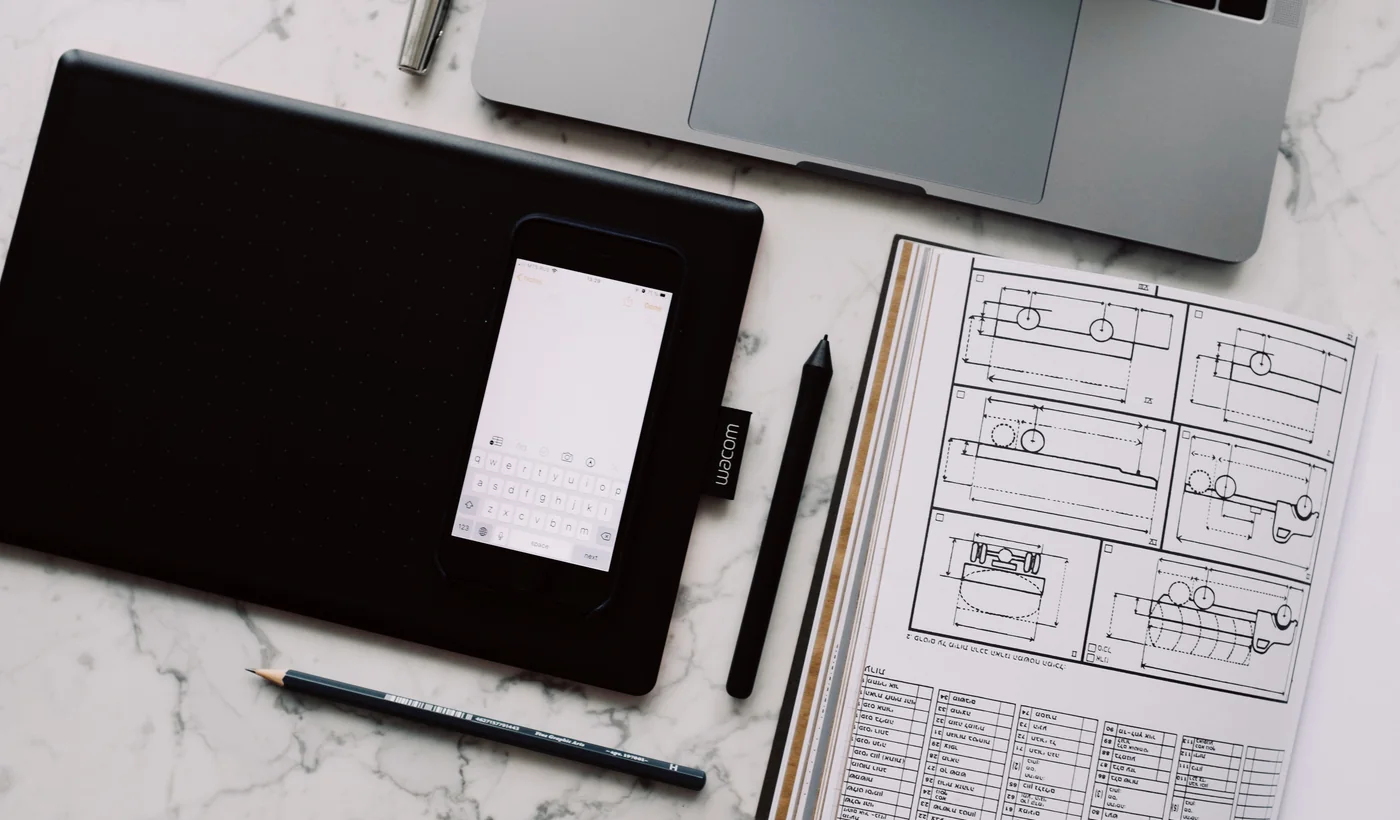 Mesa de diseño con tableta gráfica y documentación técnica