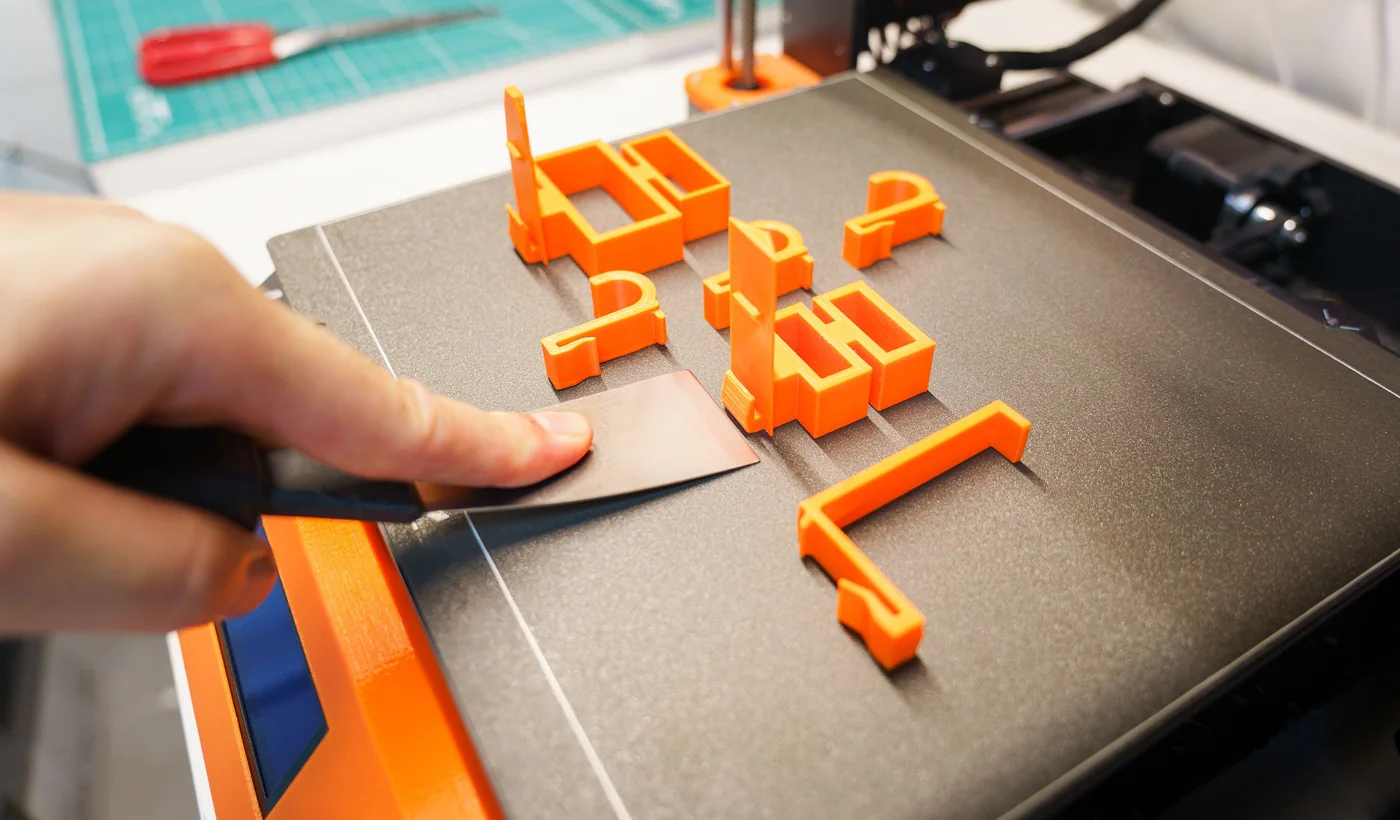 Retirada manual de una pieza terminada de la impresora 3D